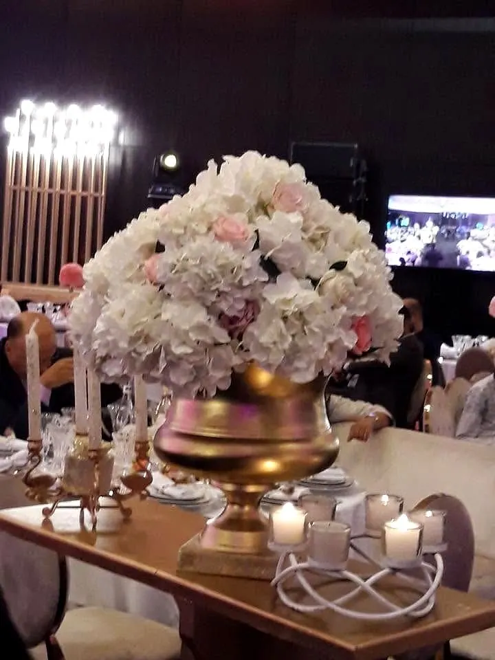 White roses in a gilded urn